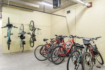 A bike rack with bikes of various colors and sizes